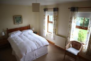 1 dormitorio con 1 cama blanca y 2 ventanas en The White House, en Enniskillen
