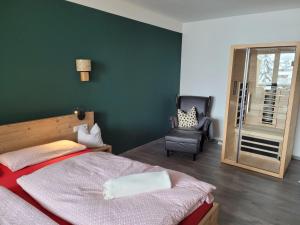 ein Schlafzimmer mit einem Bett und einem Stuhl darin in der Unterkunft Ferienwohnung Schöne Auszeit in Oy-Mittelberg