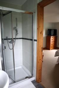 a shower with a glass door in a bathroom at The White House in Enniskillen