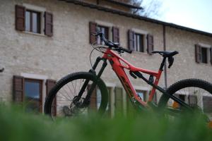 czerwony rower zaparkowany na trawie przed budynkiem w obiekcie Country House Elite w mieście Cascia