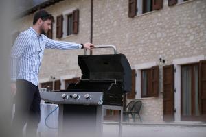 a man standing next to a barbecue grill at Country House Elite in Cascia +43 photos