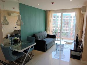 芭達雅南區的住宿－Grande Caribbean Condo Resort Pattaya，客厅配有沙发和桌子