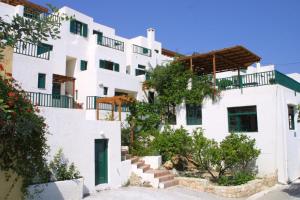 a white apartment building with a green door at Kalimera Village in Hersonissos