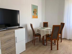 una sala da pranzo con tavolo e TV a schermo piatto di Lotus 5 a Cuxhaven