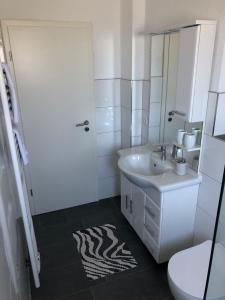 un bagno bianco con lavandino e WC di Lotus 5 a Cuxhaven