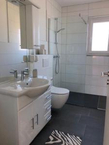 un bagno con lavandino, WC e specchio di Lotus 5 a Cuxhaven