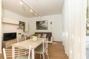 comedor y sala de estar con mesa y sillas en Casa Olivastro Millenario B, en Santa Maria Navarrese
