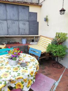 a patio with a table and a bench and flowers at I Rosai appartamento sulle colline fiorentine in Bagno a Ripoli
