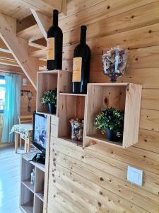 Pokój z 2 butelkami wina na ścianie w obiekcie Domki nad Narwią w mieście Dzierzenin
