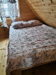 łóżko z czarno-białą kołdrą w pokoju w obiekcie Domki nad Narwią w mieście Dzierzenin +22 zdjęcia