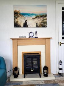 uma sala de estar com lareira e uma imagem na parede em Charming 2 Bedroom Holiday Chalet em Withernsea