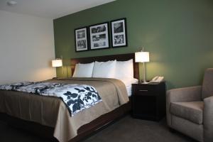 a hotel room with a bed and a chair at Sleep Inn & Suites Garden City in Garden City