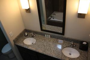 a bathroom with two sinks and a mirror at Sleep Inn & Suites Garden City in Garden City +16 photos