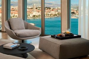 a living room with a chair and a table at Hotel Ambasador in Split