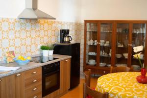 a kitchen with a stove and a table with a tableablish at Mimì Junior home, central sea view apartment in Praiano