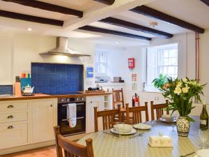 a kitchen with a table with chairs and a stove at Key House in Falkland