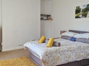 Un dormitorio con una cama con almohadas amarillas. en Key House, en Falkland