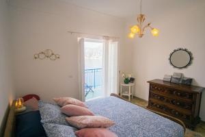 a bedroom with a bed and a dresser and a mirror at Panoramic Sea View Balcony Apartment in the Heart of Praiano, Casa Mimì Junior in Praiano