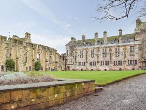 an old castle with a green lawn in front of it at Key House in Falkland