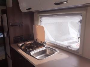 a kitchen with a sink and a stove and a window at FORD ZEFIRO 675 MOTORHOME in Wigan