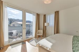 Un dormitorio con una cama y una ventana grande. en Mittelmosel Panorama Ferienwohnung, en Kinheim