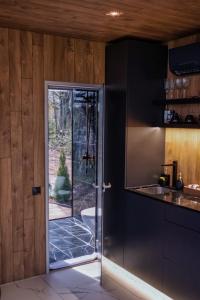 uma cozinha com uma porta que leva a um pátio em 7Mirrors em Skrīveri