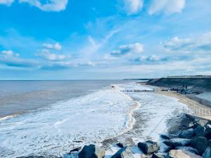 een strand met rotsen en de oceaan op een bewolkte dag bij Charming 2 Bedroom Holiday Chalet in Withernsea