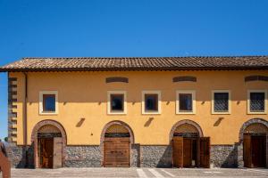 ein großes Gebäude mit vielen Türen und Fenstern in der Unterkunft Tenuta Borsari in Frascati
