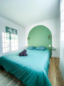 een slaapkamer met een groot blauw bed in een kamer bij Appartement avec vue sur la tour de Vésone in Périgueux