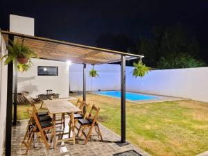 a patio with a table and chairs and a pool at Casa Roque Funes, ubicado en Cerro de las Rosas Córdoba, Ofrece, Asador, Pileta, Cercanias, Estadio Kempes, aeropuerto Ambrosio Taravella, Orfeo Superdomo, Sanatorio Allende, Casa con 2 departamentos individuales y áreas comunes in Córdoba