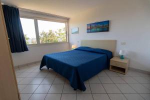 a bedroom with a blue bed and a window at Appartamenti Seccione in Portoferraio