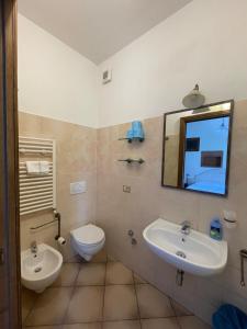 ein Badezimmer mit einem Waschbecken, einem WC und einem Spiegel in der Unterkunft La Spiga in Campi Bisenzio
