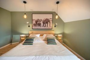 Hôtel Restaurant Le Fiacre à Quend plage في كويند: غرفة نوم بسرير وصورة فيلة