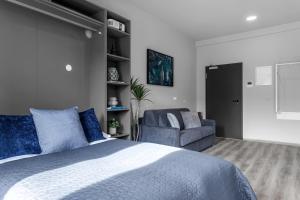 een slaapkamer met een bed en een stoel bij B18 Apartments in Reykjavík