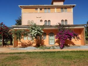a house with flowers in front of it at Pousada Florada na Serra in Serra do Cipo