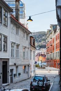 une voiture garée dans une rue abritant des bâtiments dans l'établissement Stay Strandgaten - New apartment in city center, à Bergen