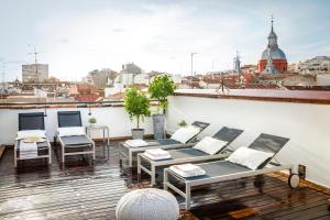 einen Balkon mit Stühlen und Tischen sowie Stadtblick in der Unterkunft Eric Vökel Boutique Apartments - Madrid Suites in Madrid