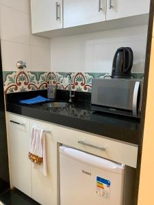 cocina con fregadero y microondas en Apartamento Encantador Leme - Prédio na Orla en Río de Janeiro