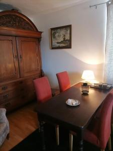 ein Esszimmer mit einem Tisch und roten Stühlen in der Unterkunft Gutshaus Dämelow Wismar in Dämelow