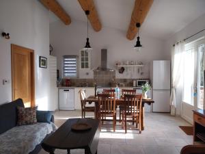 a living room with a table and a kitchen at Gîte Bienvenue Chez Nous in Ménerbes