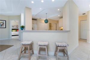 een keuken met twee krukken voor een aanrecht bij A Touch of Modern with Views Condo in Manasota Key