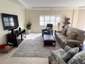 een woonkamer met een bank en een flatscreen-tv bij A Touch of Modern with Views Condo in Manasota Key