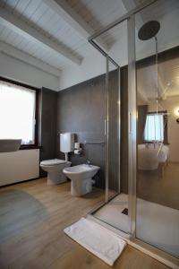 a bathroom with two toilets and a glass shower at Le Tofane, vivi la bellezza di Belluno - Ciclamino in Sòis