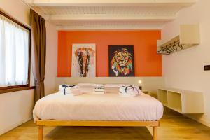 a bedroom with orange walls and a bed with towels on it at Le Tofane, vivi la bellezza di Belluno - Ciclamino in Sòis