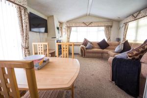 a living room with a couch and a table at 8 Berth Caravan With Wifi And Decking In Lincs Ref 78003p in Winthorpe