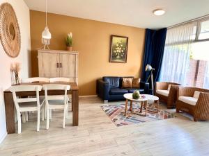 ein Wohnzimmer mit einem Tisch und einem Esszimmer in der Unterkunft Reumann Holiday Apartments: De Schelp in Zandvoort