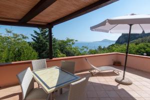 a patio with a table and chairs and an umbrella at Appartamenti Seccione in Portoferraio