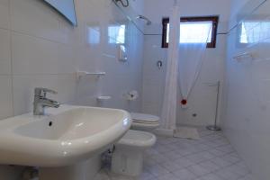 a white bathroom with a sink and a toilet at Appartamenti Seccione in Portoferraio +39 photos