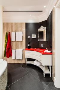 a bathroom with a red sink and a mirror at Hotel Villa e Palazzo Aminta in Stresa