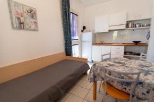 a room with a bed and a table and a kitchen at Appartamenti Seccione in Portoferraio